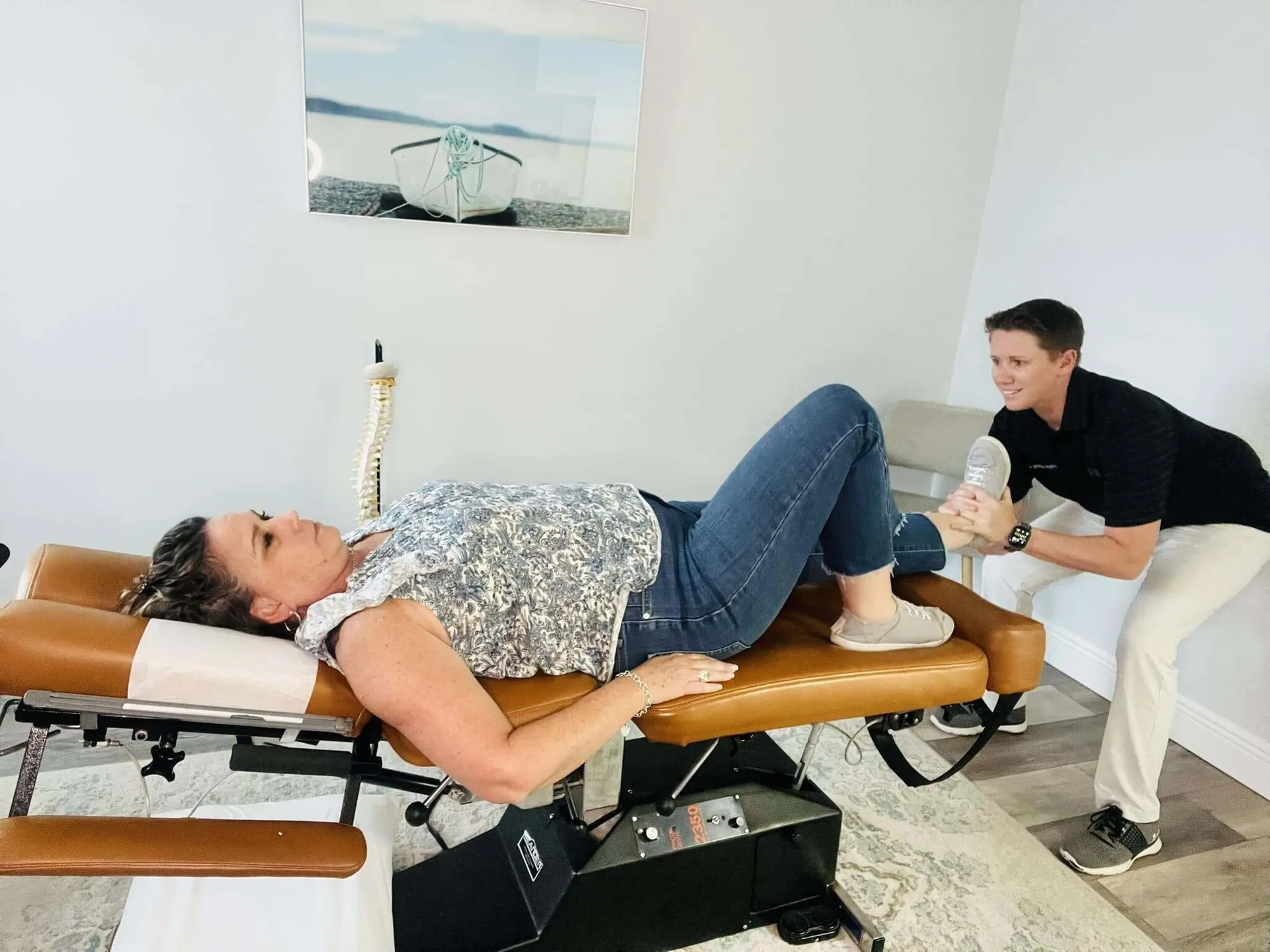 Chiropractor checking a patient's legs on a treatment table at Spinal Health Center