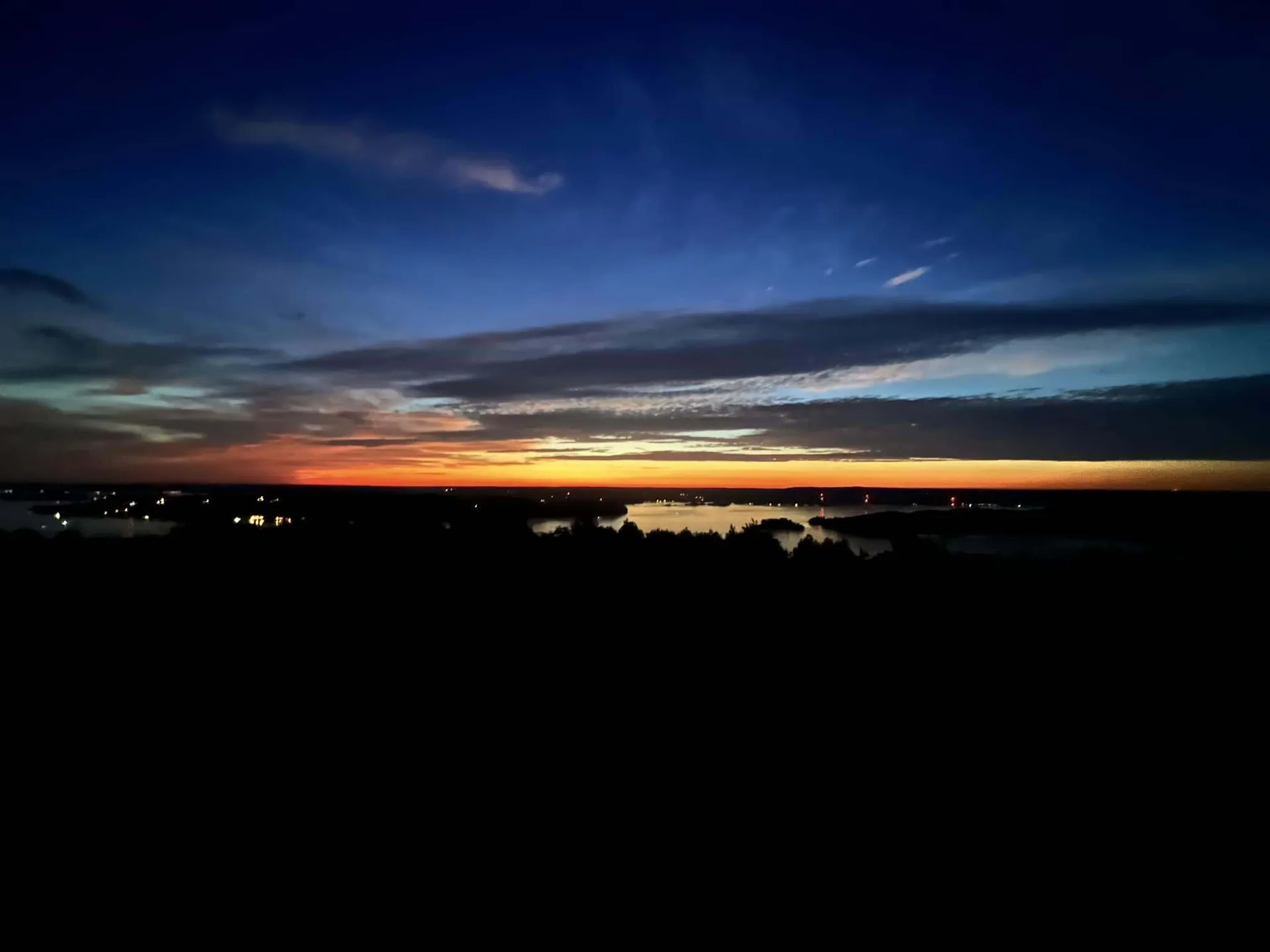 Orange sunset glowing on the horizon beneath a dark blue sky