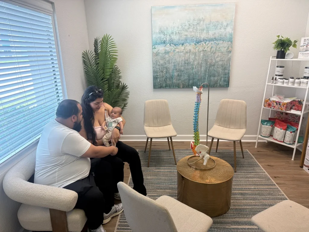 Family with a baby waiting in the bright Spinal Health Center waiting room in Vero Beach
